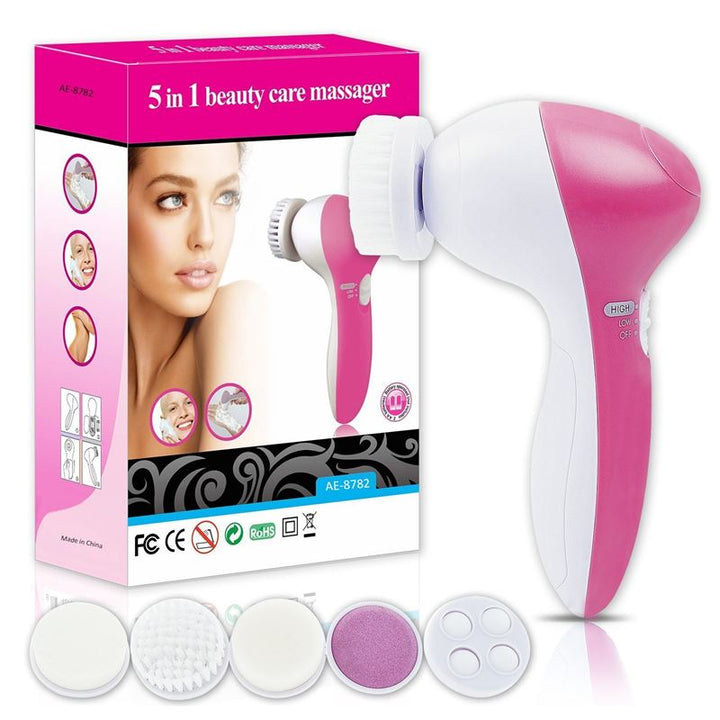 The Fashiongirl Facial Brush 5-in-1 | Facial Brush Cleanser is displayed next to its box, which showcases a womans face and product images. Five interchangeable brush and pad attachments are arranged in front for your skincare routine.