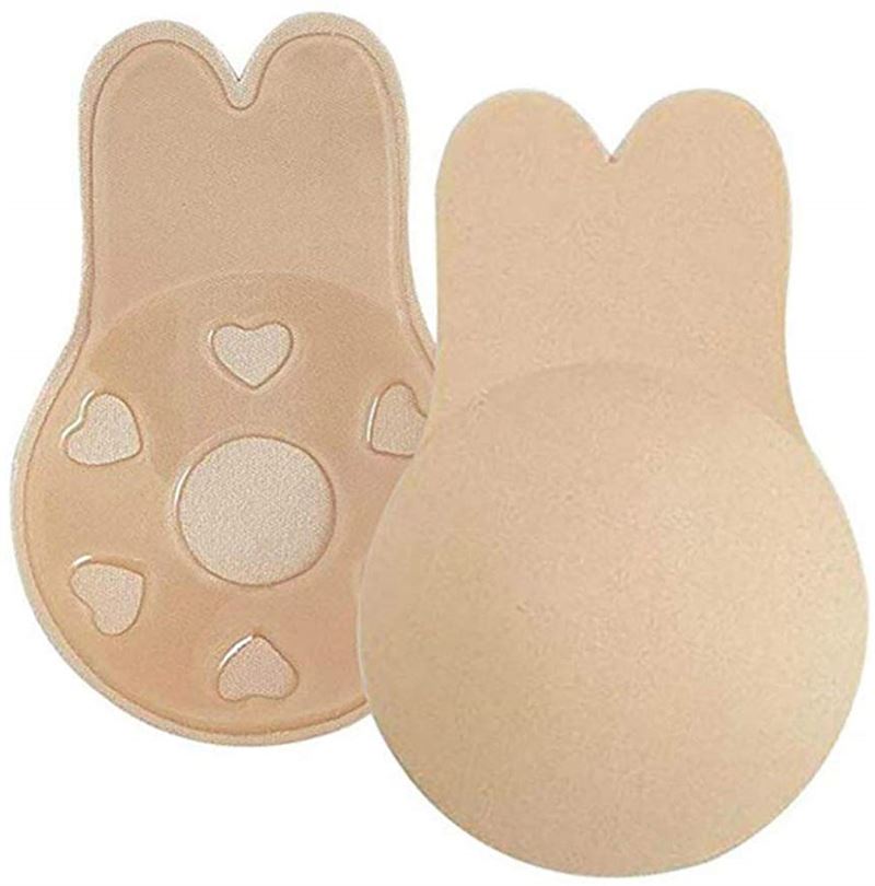 Shapelux Lifting Pads for Invisible Breast Lift are beige, reusable silicone covers with bunny-ear shapes and strong adhesive tape. One shows the smooth front; the other reveals heart-shaped cutouts and textured adhesive for a strapless bra alternative.