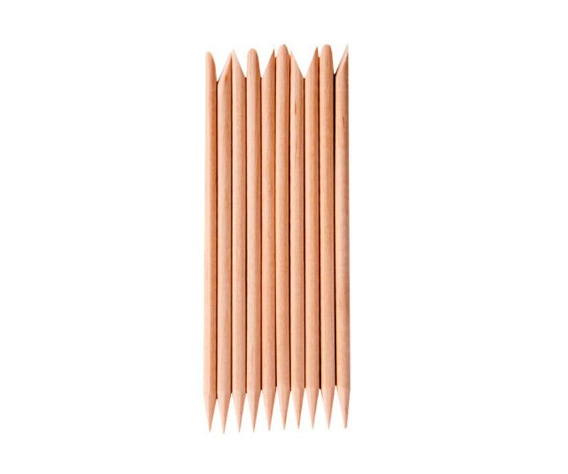 Ten wooden cuticle sticks arranged neatly, each pointed end up—an essential tool in the UNIQ Nail Starter Kit: Complete Gel Nail Set with 80W UV/LED Dryer by UNIQ, perfect for prepping nails before curing under your lamp.