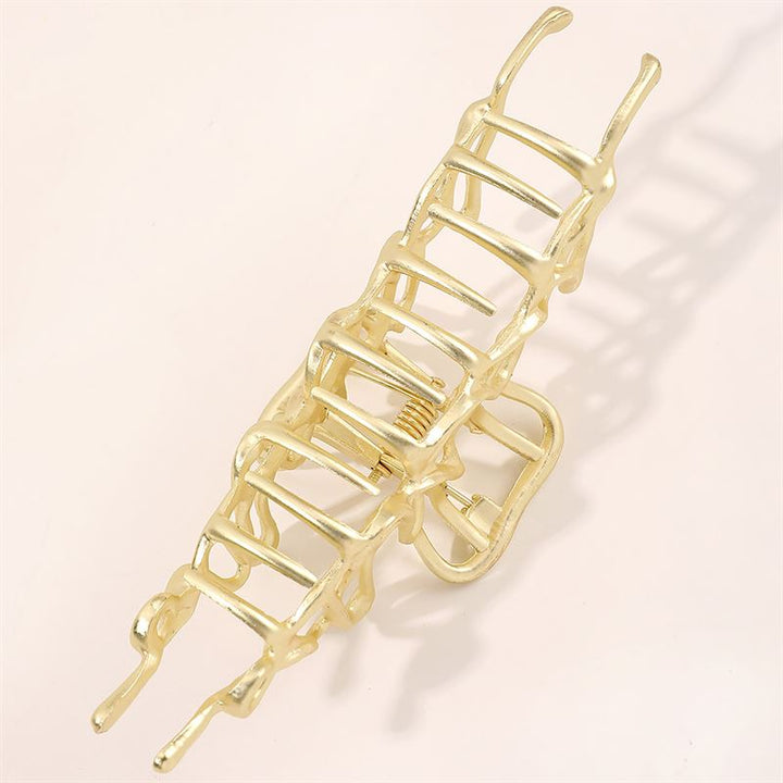 The SOHO Asli Metal Hair Claw - Silver by SOHO features a geometric, ladder-like design. Shown open against a light background, this elegant accessory highlights its spring and pronged metal structure.