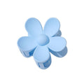 The SOHO Bloom Hair Claw in light blue features a smooth finish and rounded five-petal flower design, shown from above.