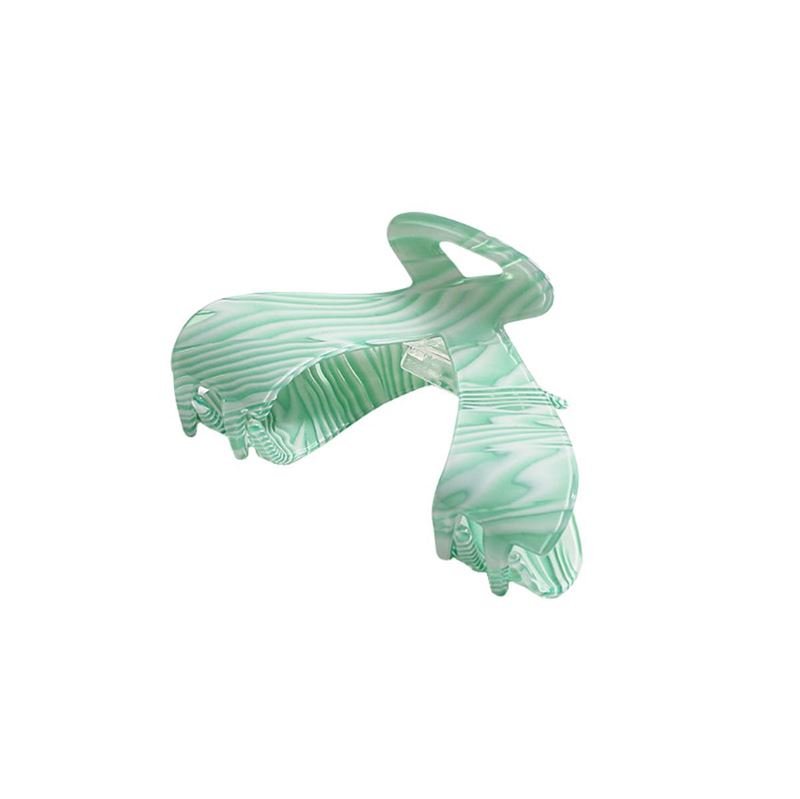 The SOHO Malou Hair Claw - Green by SOHO features a large mint green marbled design with a wavy pattern and wide, curved prongs, shown against a white background.