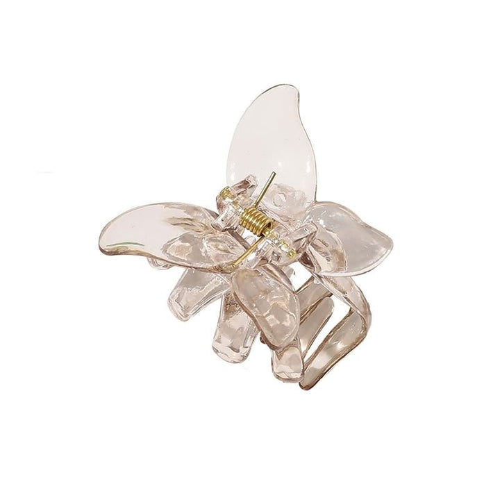 The SOHO Naja Hair Claw - Espresso by SOHO is a transparent brown hair accessory with a metallic spring, combining style and practicality for any occasion.