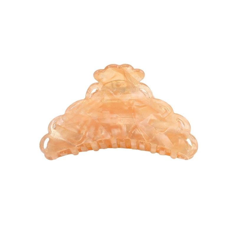 The SOHO Naomi Hair Claw - Sunshine by SOHO is a peach-colored, semi-transparent clip with a scalloped design and interlocking teeth—ideal for keeping your hairstyle secure.