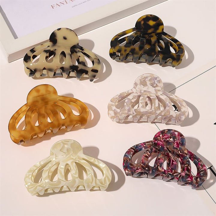 The SOHO Olivia Hair Claw - Dark Tortoise by SOHO is showcased among six uniquely marbled hair clips arranged in two rows, with each claw featuring distinct beige, brown, black, ivory, white, or pink tones.