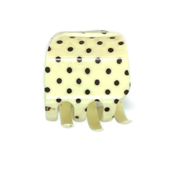 The SOHO Polkadot Hair Claw - Vanilla by SOHO, featuring a cream base with black polka dots and four wide prongs, is shown against a white background.