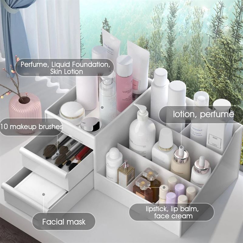 The UNIQ Cosmetic Organiser with Two Drawers, White - P110 by UNIQ neatly stores skincare and makeup like labeled bottles, perfume, brushes, masks in drawers, and lipsticks—all arranged by a window with a view of greenery.